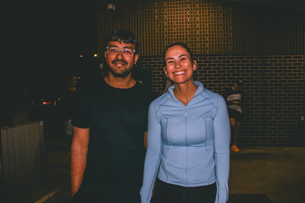 Two smiling runners standing together after a night run